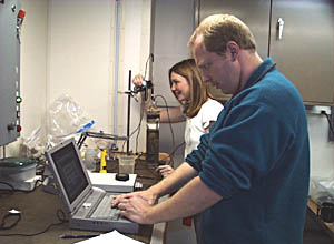 Liz McCliment adjusts the position of the electrodes in the core, while Martial Taillefert watches the data as it is plotted onto the computer. 