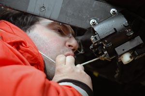 Engineering assistant Josh Eaton gets in close, blowing into the MOCNESS net&rsquo;s flow meter to test its action. (Photo by Larry Madin, WHOI)