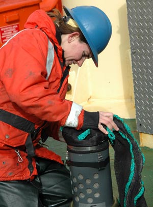 Kerri Scolardi fastens the collecting containers onto the net, before it is towed. (Photo by Larry Madin, WHOI)