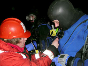 As dive tender, Wally Fulweiler helps Byron fasten the buoyancy vest, a task difficult for divers wearing gloves.