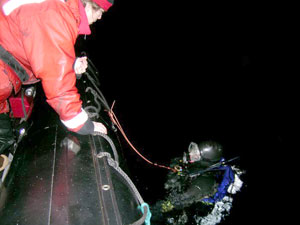 As Kerri Scolardi surfaces after the dive, Wally is ready to lift her weights and tank into the dive boat.