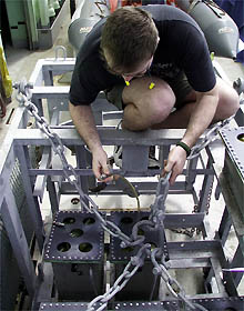 Del Bohnenstiehl puts the finishing touches on the oil compensation lines for the Towed Camera Sled batteries. 