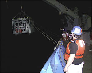 The Towed Camera Sled being launched over the starboard rail. Ed Popowitz is in the foreground and Jerry Graham, the Bosun, is directing the operations in the background. 