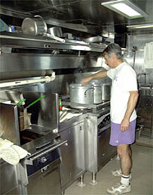 Dan Fornari cooking pasta sauces in the galley for tonight's dinner. 