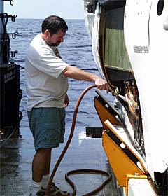 Bob Waters sprays sea water into Alvin's electrical connectors to help the pilot isolate the ground. 
