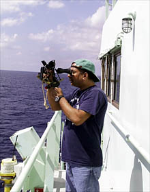 Diego Mello, the 2nd mate, uses a sextant to determine the latitude position of the ship by “shooting” the sun at noon. 