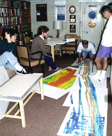 Chief Scientist Dan Fornari (far right) directs a meeting with his colleagues (from left, Maya Tolstoy, Rachel Haymon, Mike Perfit, kneeling, and Dan Scheirer) to discuss the plan for the first survey area on the East Pacific Rise between 9-10°N latitude. Multibeam bathymetry maps laid out on the floor provide key information on the mid-ocean ridge crest's topography and structure, which guides scientists to sites of potential volcanic eruptions. 