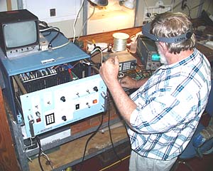 Tom Crook, chief navigator for Woods Hole Oceanographic Institution’s Deep Submergence Group, tests relay signals for the transponder that will be used to help navigate the towed mapping systems (DSL-120 and Argo II) near the seafloor. 