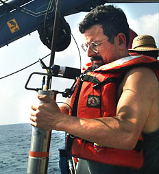 Shipboard Technician Rob Palomares attaches one of five Miniature Autonomous Plume Recorders (MAPRs) to the wire, just above the depressor clump. The MAPRs will measure seawater properties and show us where hydrothermal vents may be located on the mid-ocean ridge crest. 