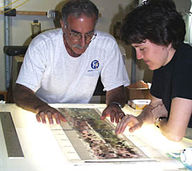 Mike Perfit and Maya Tolstoy at a light table studying DSL-120 sonar images laid on top of bathymetric contour maps of the same area. They are deciding where to dredge the seafloor for rock samples. 