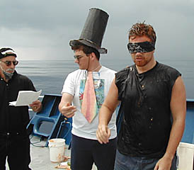 The Royal Prosecutor (Mike Perfit) reads the charges against “Klutz” Pollywog (Ben Wigham) as the Royal Public Defender (Dan Scheirer) leads him to face King Neptune.