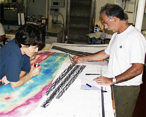 Maya Tolstoy and Mike Perfit reviewing the DSL-120 sonar data and the multibeam bathymetry data (colored map that Maya is leaning on). They are picking targets for dredging to sample young lava flows on the seafloor of the Galapagos Rift valley. 
