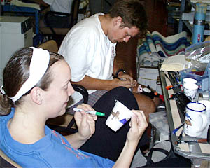 Julia Getsiv and Ben Wigham decorate styrofoam “shrink“ cups this evening as they wait for the DSL-120 sonar fish to be recovered and the dredging operations to start.