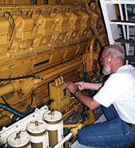 Chief Engineer Ron Wheatley checking one of R/V Melville&rsquo;s main engines.