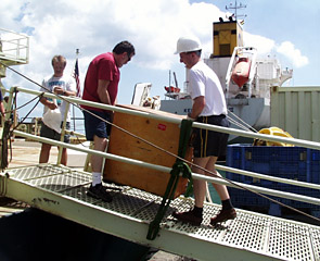 Scientists Marvin Lilley and Darryl Green pitch in to load smaller boxes on the Knorr.  