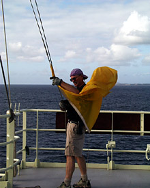 Second Mate Doug Mayer hoists the yellow quarantine flag. This signals that the Knorr has not yet cleared immigration and customs in Mauritius. As soon as the ship docks, the immigration and customs officials board and clear the ship. Then the flag is taken down.  