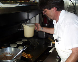 Knorr’s Cook Chris Poulin preps pancakes for the hungry morning crowd. He has been in the food business for 25 years, but cooking at sea for just six months. “It’s just like a restaurant only we’re on the ocean,” he says. “I like it because I get to travel, see the world, and get paid to do it. I can dig that.” Chris makes a tasty cheese and vegetable omelette.  
