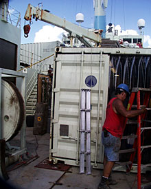 After the supplies arrive, the containers create a maze on the decks for hard-working crew members like Seaman Ed Graham to navigate.  