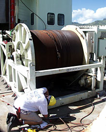 Members of the Deep Submergence Operations Group lower Jason and other vehicles to the seafloor using the fiber optic cable on this winch drum. Stretched out, the cable measures six miles. The cable sends electricity down to the ROV for controlling lights, computers and all other electronics on the vehicle. It also transmits data back to the control van on Knorr.  