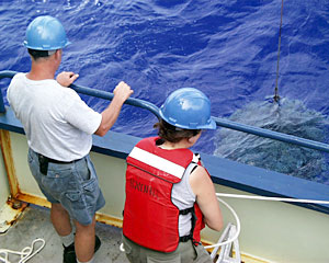 Shipboard tech Amy Simoneau and Bosun Alan Hopkins watch as the winch lowers the CTD down to a water depth of 4,000 meters, or about two and a half miles. 