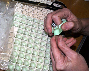 Researchers will use dozens of vials to store samples collected from the hydrothermal vent site. Biologist Cindy Van Dover carefully wraps labels around the pinky-sized glass bottles.  