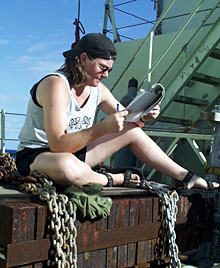 Lacking a deck chair, biologist Shana Goffredi manages to find a comfortable spot to read. She works for the Monterey Bay Aquarium Research Institute in California and studies gene flow and diversity of vent and cold seep animals, such as clams and tube worms. On this cruise, she is researching mussels and crabs. 