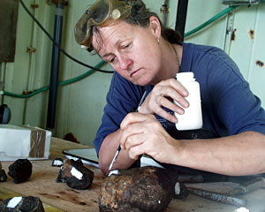 Geochemist Susan Humphris labels rocks collected in the dredge today. She paints a white label and then gives each rock its own sample number. 