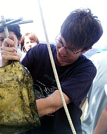  After the elevator arrives on deck, microbiologist Colleen Cavanaugh pulls snails and other organisms out of a scoop. 