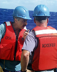 Geologist Dan Fornari and Bosun Al Hopkins talk by radio with the Mate on the bridge before launching the dredge.  