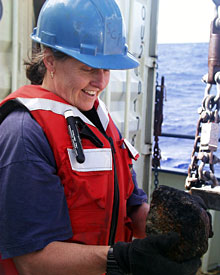 Geologist Susan Humphris is all smiles as she looks at one of the volcanic rocks brought up in the dredge.  