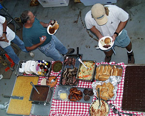 Bosun Al Hopkins (left) and Chief Mate Kent Sheasley pile on the flank steak and other grilled foods during tonight’s celebration feast on Knorr’s main deck. 