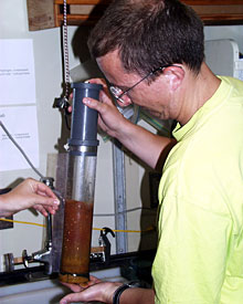 Chemist Darryl Green examines a push core sample recovered on today’s dive. The rusty-orange color comes from iron oxide that precipitates from the hydrothermal plume above the vent field.  
