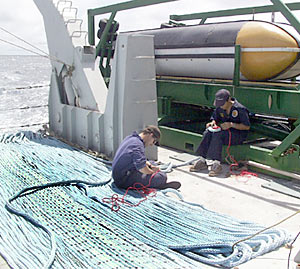 Todd Ericksen and Steve Tottori prepare the drogue line for the MR1 sonar fish. The drogue helps to stabilize the sonar fish as it travels through the water at 8 knots.  