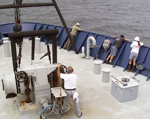  Victor Barnhart, the Bosun, drops the anchor as crew members look over the side to check how much anchor chain is going out. 