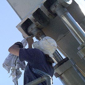  Lorna Allison, Ordinary Seaman, oils the hydraulics on one of the ship's cranes. 