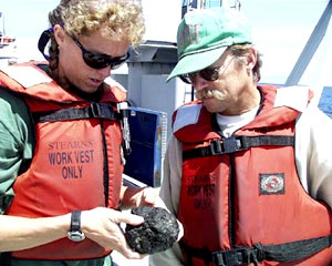 Karen Harpp and Bob Reynolds look over one of the rock samples dredged from Fernandina's northwest rift zone. 