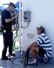 Tim McDaniel (left), Oiler, and Billy Wells, Wiper, work to clear a blocked drain near the hanger on the Main Deck.  