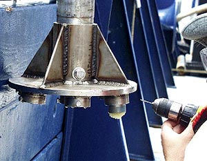   The cups of wax (seen just below the drill bit) are removed from the core shaft and taken to the lab to be processed. Here, Rob Otto fixes one of the bolts that hold the wax cups. It was sheared off during impact and had to be drilled out and replaced.