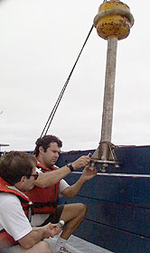  Mark Kurz, left, and Josh Curtice prepare the wax corer for deployment. Mark is holding one of the steel cups that hold the wax. Josh is installing them in the corer head. It holds seven cups of wax. 