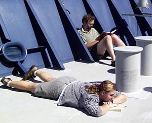 After their watch is over Kate Buckman and Alberto Saal relax in the sunshine on the fore deck.  