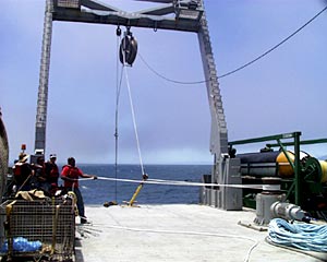  From a safe distance away, Butch Harty, Able Seaman, hauls line as the capstan pulls up the tow wire. 
