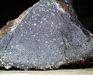  Samples are slabbed, or cut into pieces, using the rock saw in order to see crystals in the interior. Dredge 34 has yellowish-green crystals of olivine (an iron-magnesium silicate mineral) and white plagioclase (feldspar - a calcium-aluminum silicate mineral). The sample is resting on the outer glassy surface.  