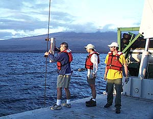  Dan Fornari (left) attaches the pinger on the trawl wire with the help of Joe Licciardi (center) and Jeremy Haney.  