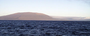  Cerro Azul volcano at sunset today. View is the to east, note the clouds that have banked up against the south side of the volcano. The prevailing winds are from the south in this area. 