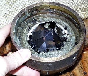  The ‘core catcher’ and the sample collected in the nose cone of the sediment corer. The core catcher (the thing with the shiny metal fingers) is placed at the base of the corer and allows sediment to enter but not to exit. In this case there was a hard layer of volcanic gravel that stopped the corer from going very far into the sediment. We did recover a nice sample of the surface sediments and some volcanic glass. 