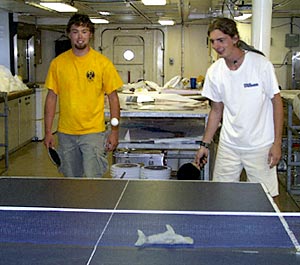  With the doubles ping-pong tournament about to begin, Jeremy Haney (left) and Ben Grosser hone their skills. “Hammy” the hammerhead shark is there to help. 