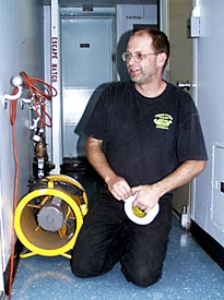 Tim McDaniel puts a fan in the corridor to dry out some excess water from a small leak in one of the staterooms down below decks.  