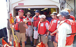 Second Mate Craig Dickson demonstrates the Search and Rescue Transponder (SART) during the Fire and Boat Drill today.