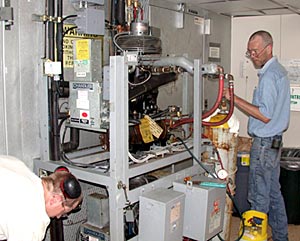  First Engineer Jeff Little, left, and Second Engineer Jim Schubert replace the compressor for the walk-in freezer used by scientists to store and work on samples.