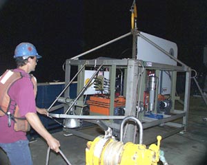  The ship’s crew launches a camera system to collect images and CTD data from the seafloor in the area of Rose Garden. The large metal cage provides protection for the equipment and lights if the system accidentally bumps into the seafloor.